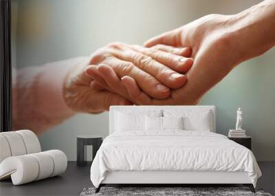 Old and young holding hands on light background, closeup Wall mural