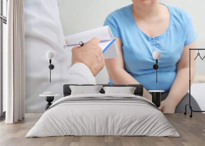 Overweight woman discussing test results with doctor in hospital Wall mural