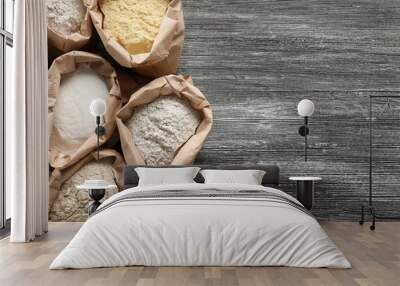 Paper bags with different types of flour on wooden background Wall mural