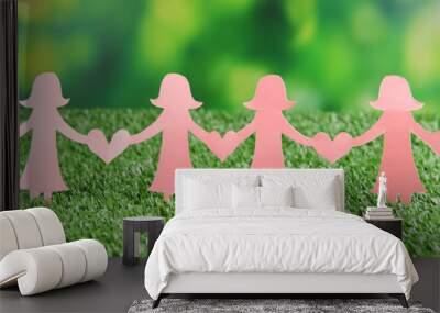 Paper people on green grass, close up Wall mural