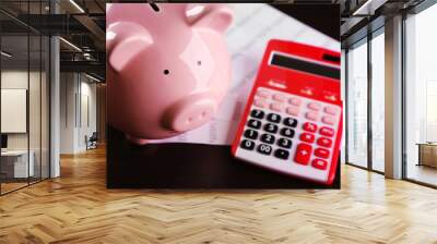 Pig moneybox and calculating equipment on desk closeup Wall mural