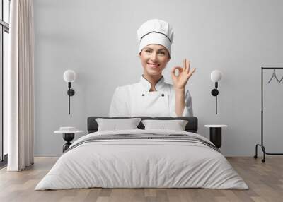 Portrait of female chef on light grey background Wall mural