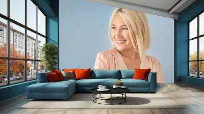 Portrait of smiling mature woman on color background Wall mural