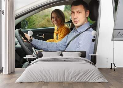 Portrait of young beautiful  couple sitting in the car Wall mural