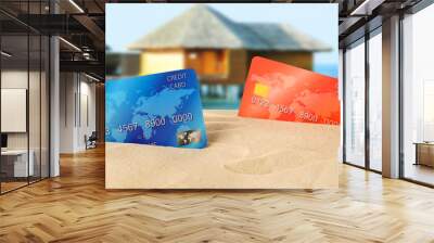 Red and blue bank cards in sand on blurred resort background Wall mural