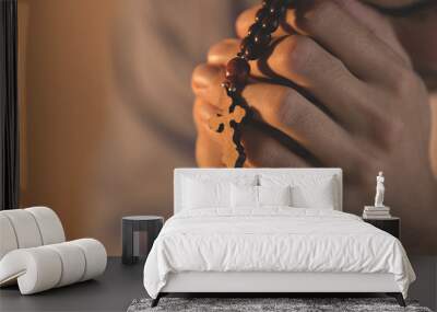 Religious young man with rosary beads, closeup Wall mural