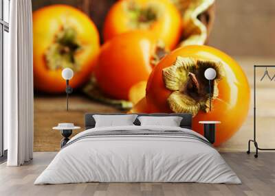 Ripe persimmons on wooden background Wall mural