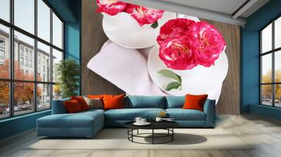 Roses in cups on napkin on wooden background Wall mural