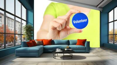 Round volunteer button in hand of girl isolated on white Wall mural