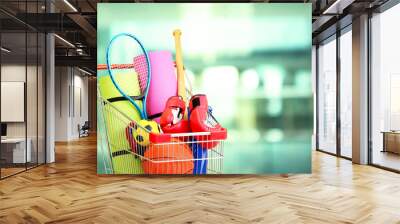 Shopping concept. Shopping cart with sport equipment Wall mural