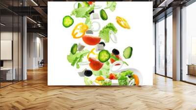 Sliced vegetables falling into bowl with salad on white background Wall mural