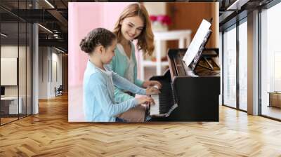 Small girl learning play piano with teacher Wall mural