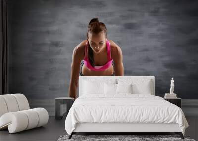 Sporty young woman making exercise on gray background Wall mural