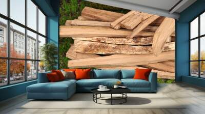 Stack of firewood on grass close up Wall mural