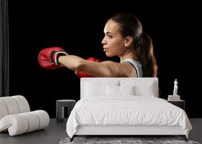 Strong woman in boxing gloves on black background Wall mural