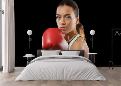 Strong woman in boxing gloves on black background Wall mural