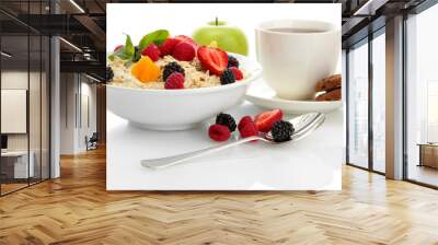 tasty oatmeal with berries and cup of tea, isolated on white Wall mural