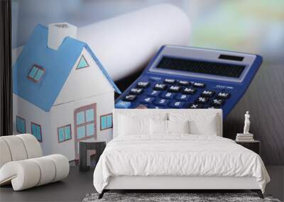 Toy houses and calculator on table close-up Wall mural