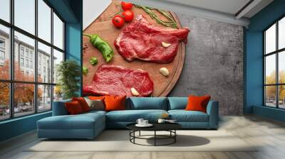 Two raw steaks with rosemary and vegetables on kitchen table Wall mural