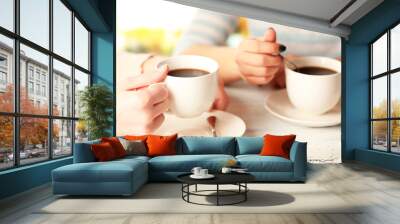 two women with cups of coffee on bright background Wall mural