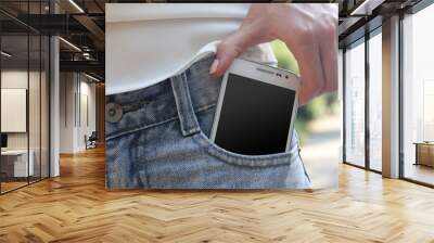 white smart mobile phone in jeans pocket Wall mural