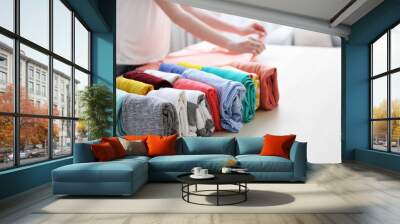 woman folding clothes on table Wall mural