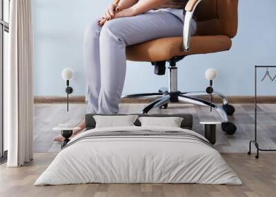 woman sitting on the office chair indoors Wall mural