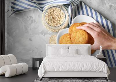 Woman taking oatmeal cookie from plate Wall mural