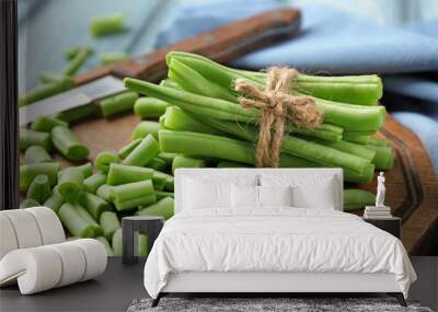 Wooden board with fresh green beans on table, close up Wall mural