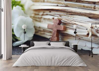 Wooden cross with flowers and old book, closeup Wall mural