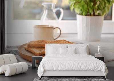 Wooden plate with tasty toasted bread on table Wall mural