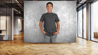 Young African American boy in blank gray t-shirt standing against textured wall Wall mural