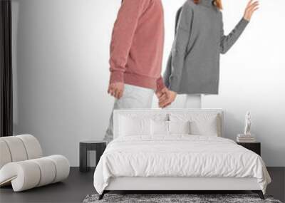 Young couple in casual clothes walking on white background Wall mural