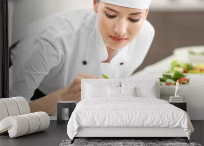 Young female chef cooking in kitchen Wall mural