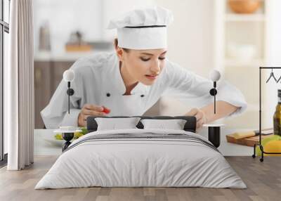 Young female chef with tasty dishes in kitchen Wall mural