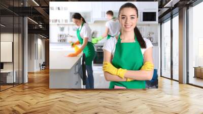 Young female cleaner at work in kitchen Wall mural