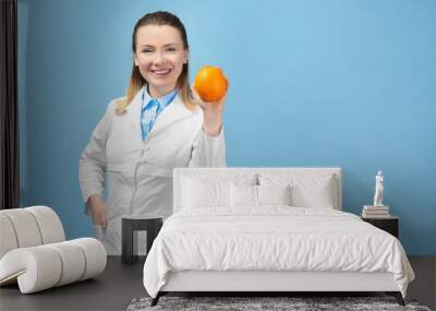 Young female nutritionist on light color background Wall mural