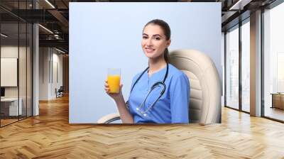 Young female nutritionist on light color background Wall mural