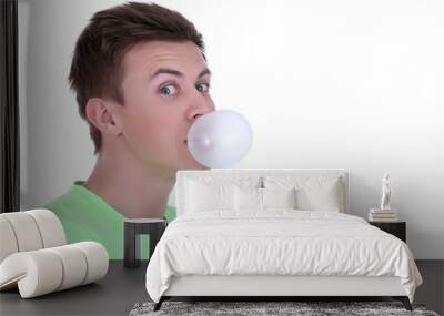 Young man blowing bubble of chewing gum isolated on white Wall mural