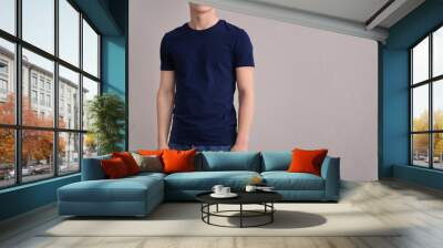 Young man in color t-shirt on light background. Mockup for design Wall mural