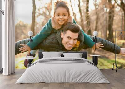 Young man playing with little African-American girl outdoors on sunny day. Child adoption Wall mural