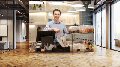 Young man standing in store. Small business owner portrait Wall mural