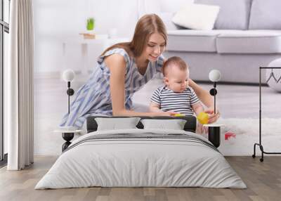 Young mother and cute baby playing on floor at home Wall mural