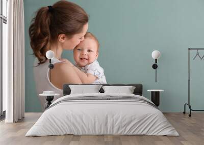 Young mother with her cute little baby on grey background Wall mural