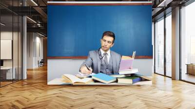 Young teacher sitting in school classroom Wall mural