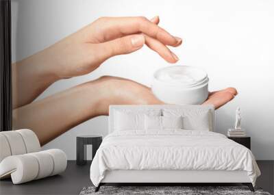 Young woman holding jar of hand cream, on white background Wall mural