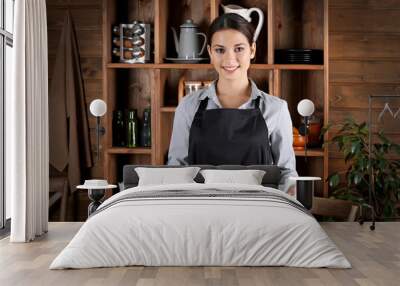 Young woman in apron holding baking tray with cookies on kitchen Wall mural