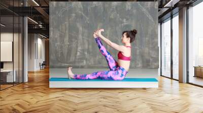 Young woman practicing yoga on grey background Wall mural