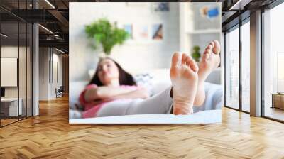 Young woman sleeping on sofa at home Wall mural