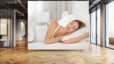 Young woman sleeping on white pillow in bed Wall mural